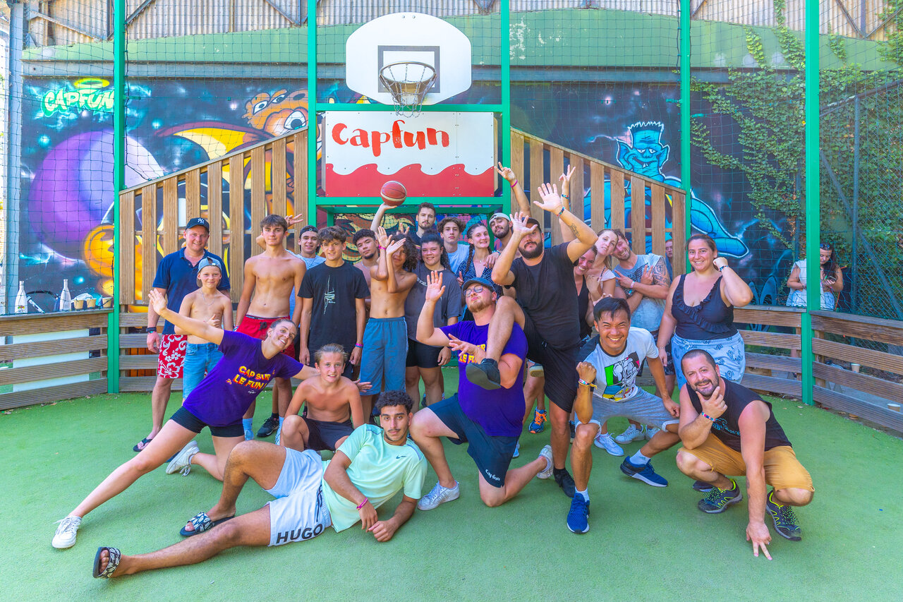 Groupe joyeux sur terrain multisport avec panier de basket au camping CAPFUN R�gni�re � Villette d'Anthon.