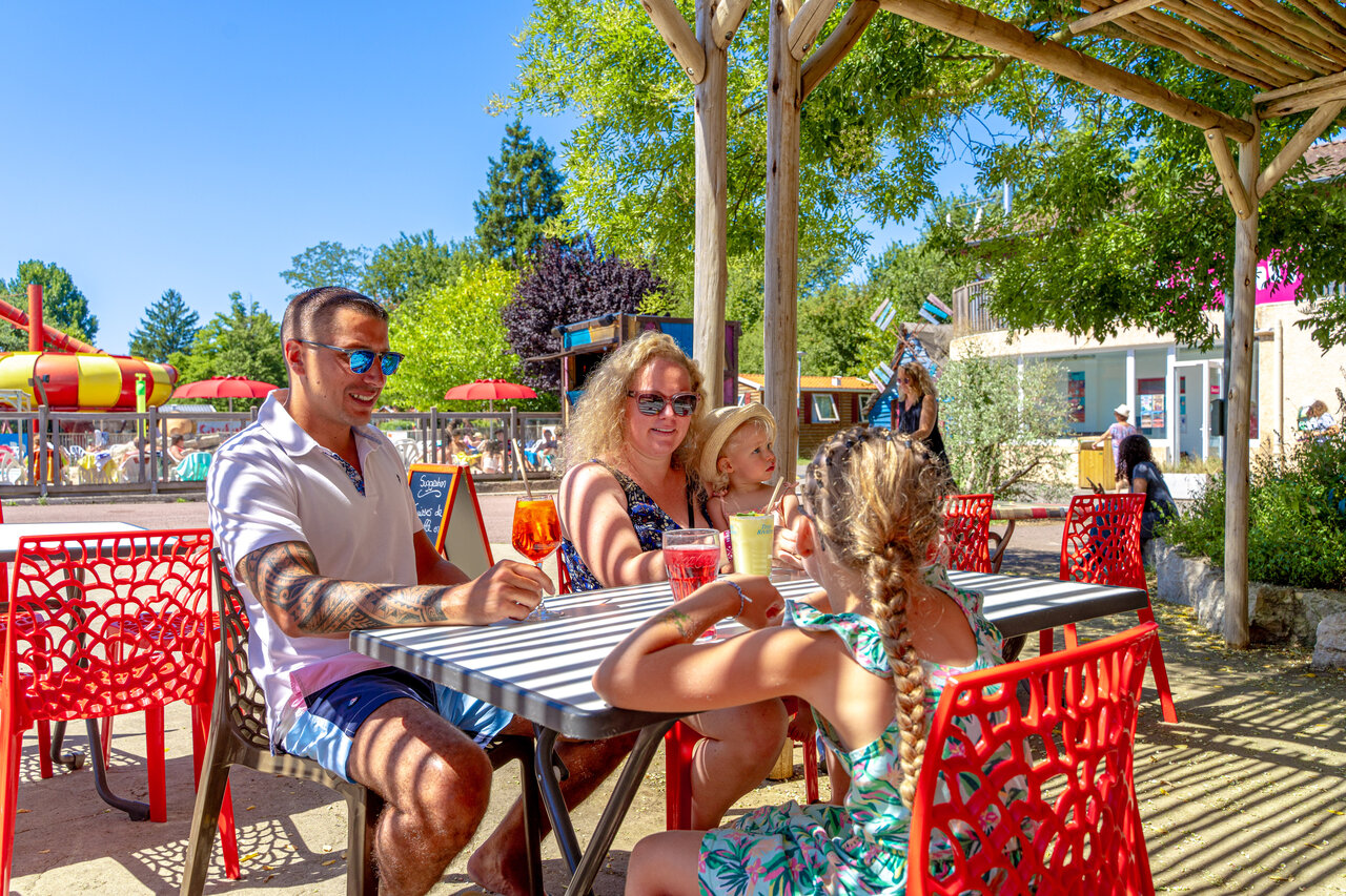 Famille en terrasse, piscine, toboggan au camping CAPFUN R�gni�re : Maisons dans les arbres � Lyon � Villette d'Anthon (38).