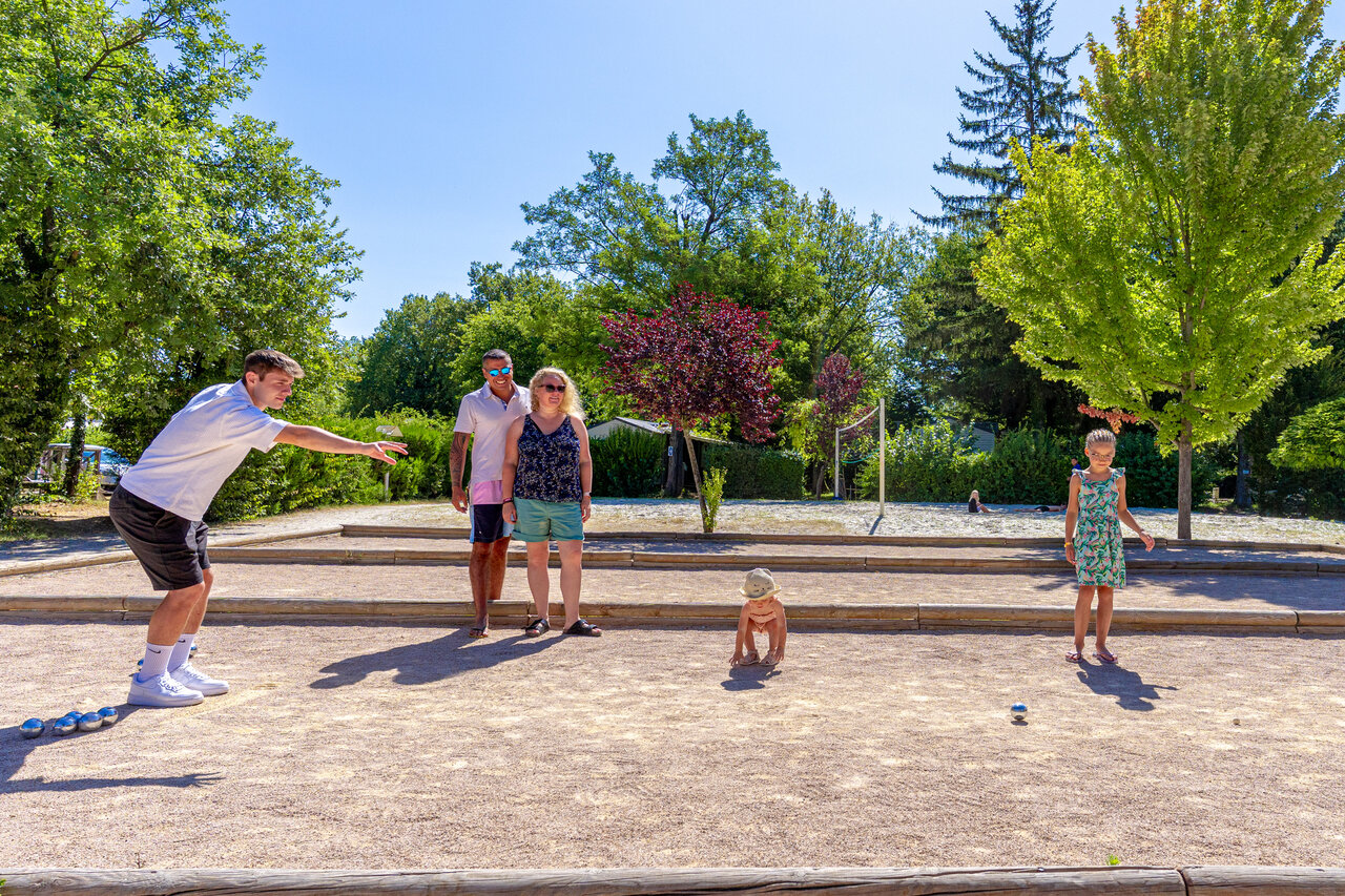 Famille jouant � la p�tanque sur terrain au camping CAPFUN R�gni�re � Villette d'Anthon.