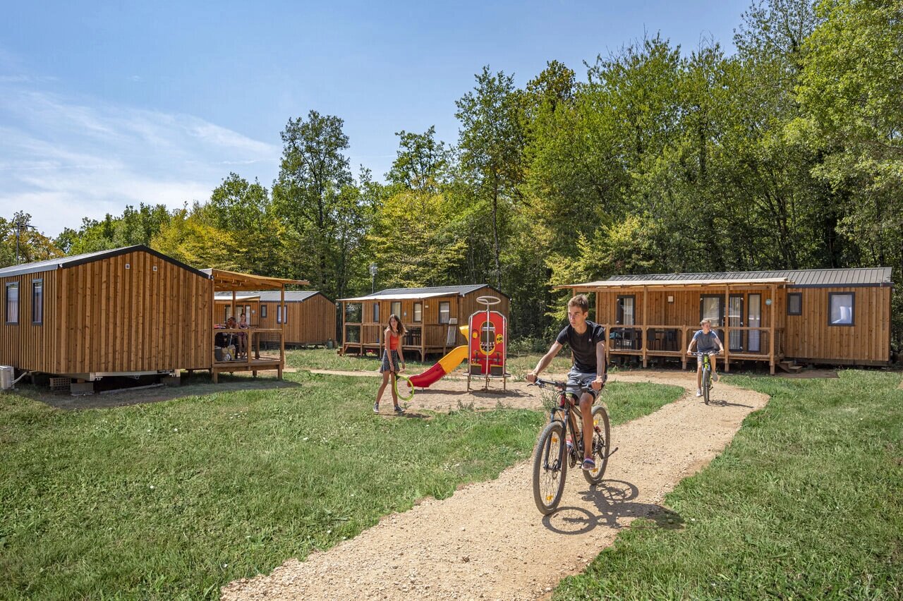 Mobil-homes, aire de jeux, enfants � v�lo au camping CAPFUN La Rivi�re � Valence-en-Poitou.