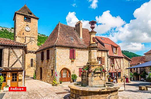 Place du village d'Autoire avec fontaine et tour horloge, Lot, Occitanie.