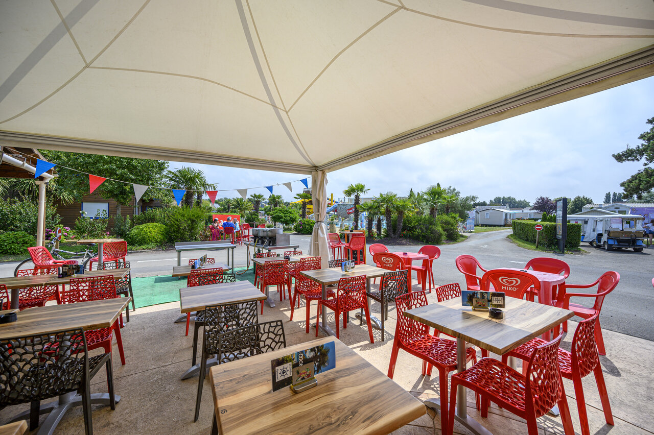 Terrasse restaurant-bar ombrag�e au camping CAPFUN La Route Blanche � Breville sur Mer (50).