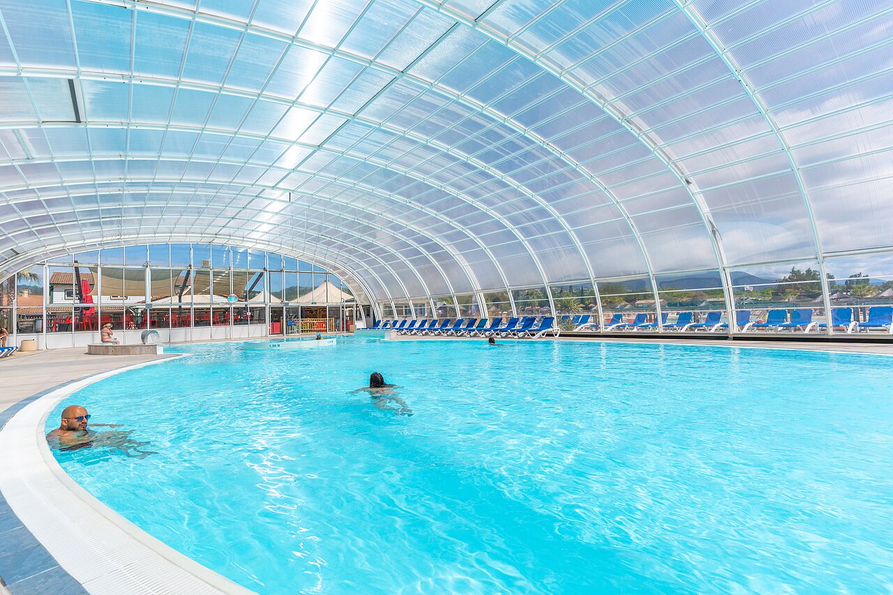 Piscine couverte, baigneurs et transats au camping CAPFUN Sagittaire � VINSOBRES (26).