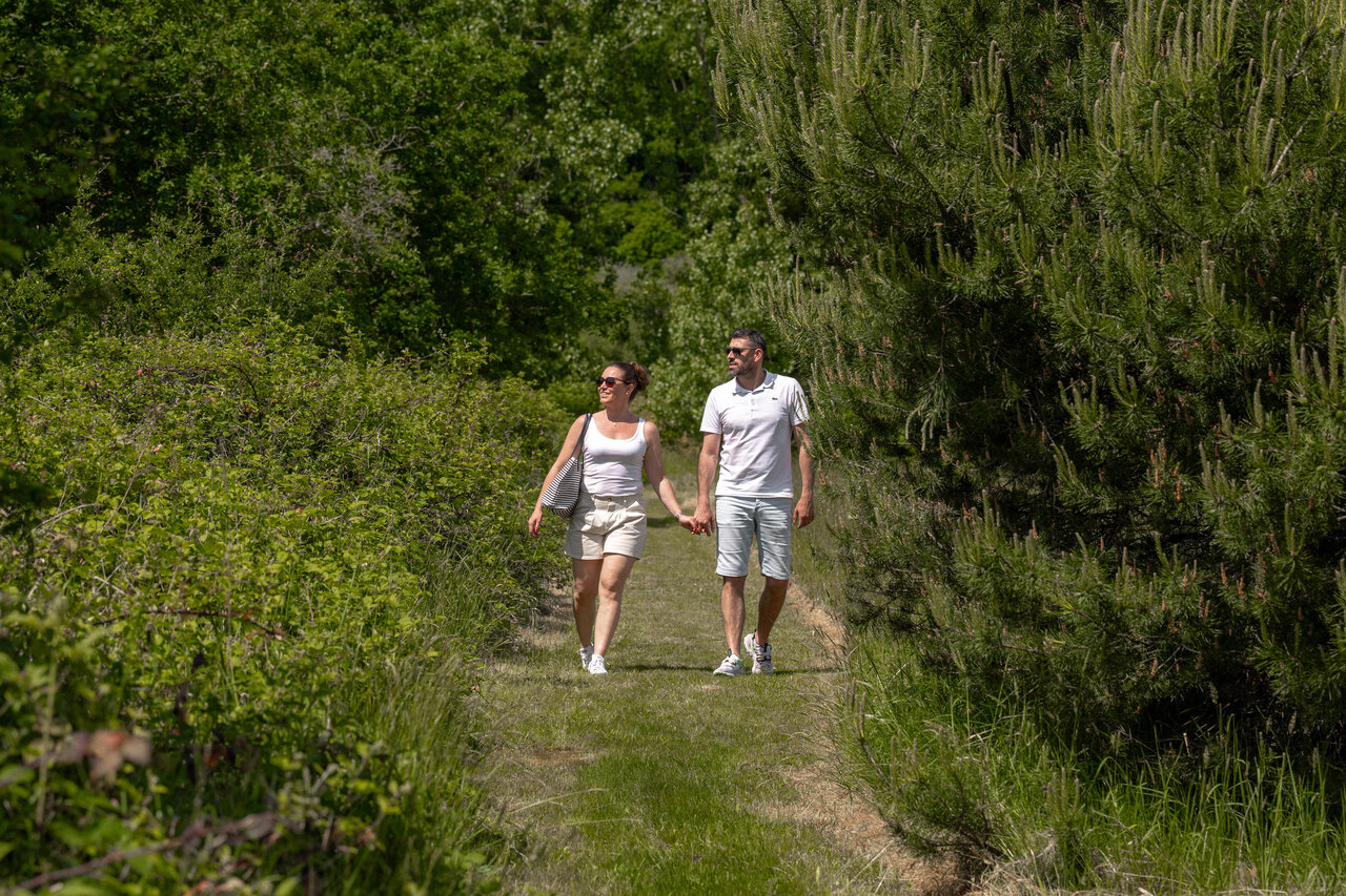 Couple marchant sur sentier naturel verdoyant au camping CLICOCHIC � Cheverny.