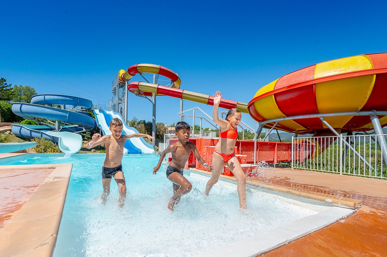 Enfants s'amusant dans la piscine avec toboggans g�ants au camping VAGUES OCEANES Soleil de Provence � Saint-Romain-en-Viennois.