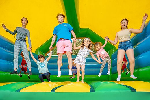 Enfants et animateur sautant sur jeu gonflable au camping VAGUES OCEANES Soleil de Provence.