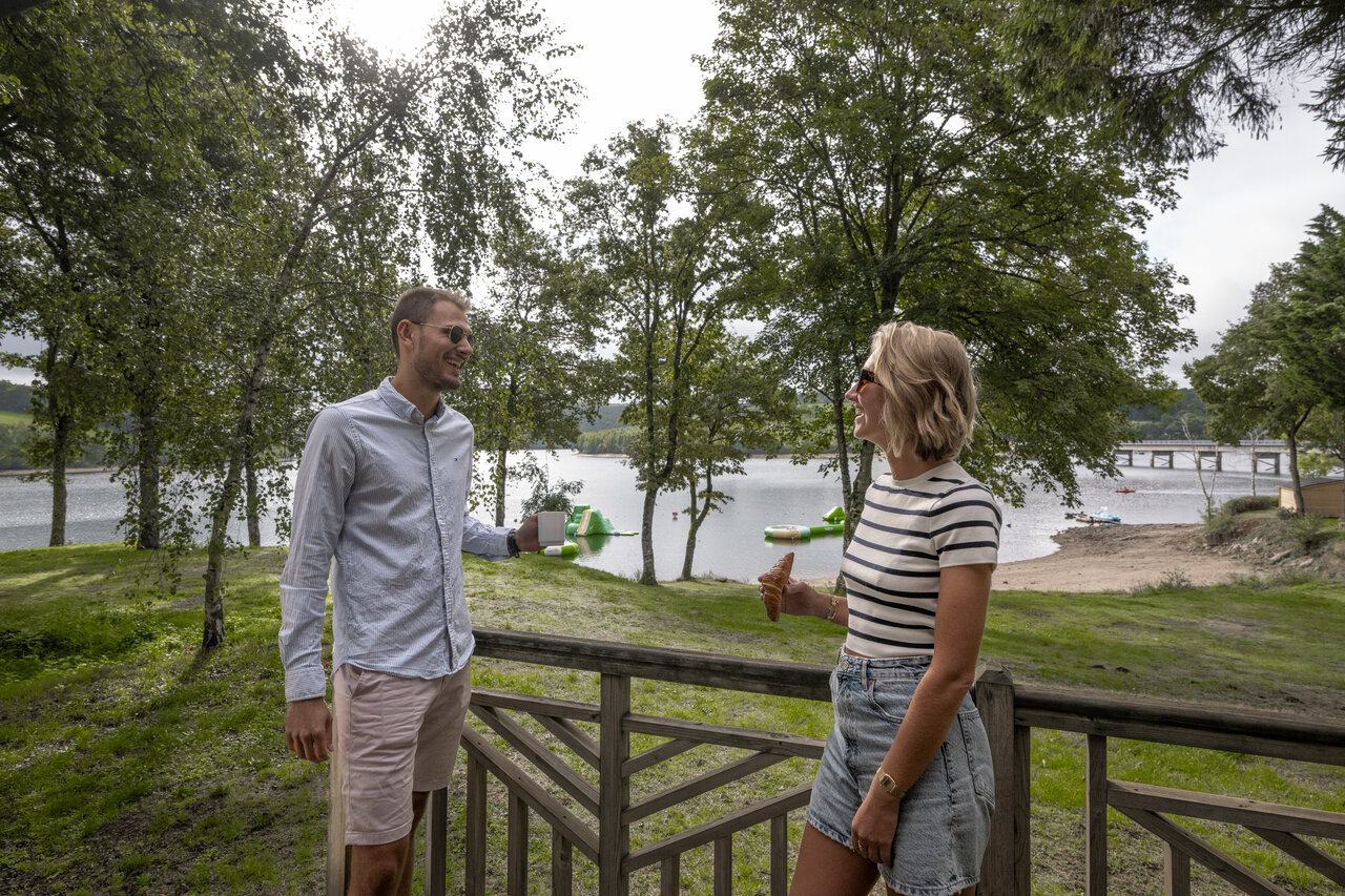 Couple sur terrasse, lac, activit�s nautiques au camping CLICOCHIC Soleil Levant � Canet-de-Salars.