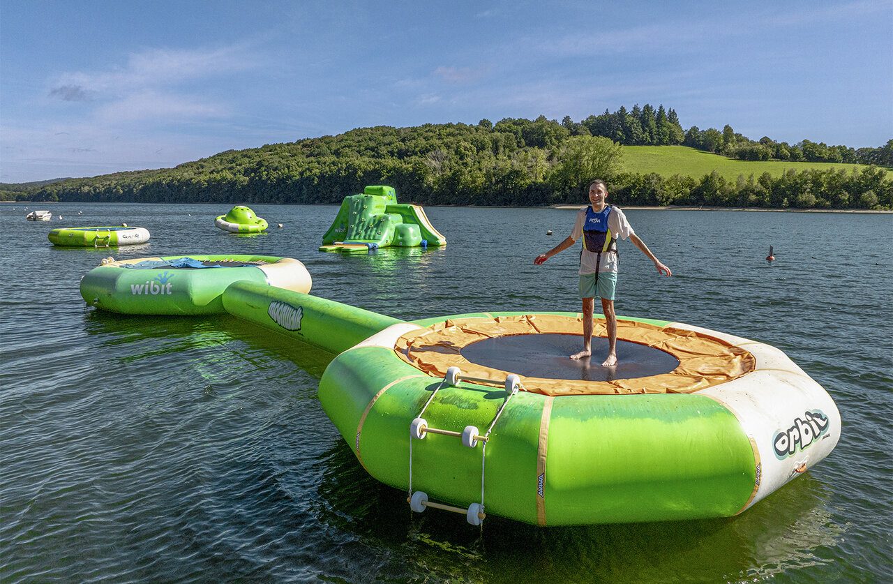 Trampoline flottant, parc aquatique sur lac au camping CLICOCHIC Soleil Levant.
