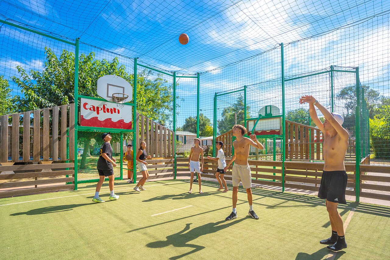 Jeunes jouant basketball sur terrain multisport au camping CAPFUN Soubeyranne � REMOULINS (30).