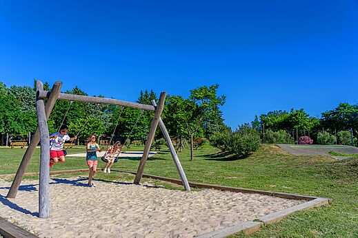 Balan�oire en bois avec enfants jouant sur le sable au camping CAPFUN Soubeyranne � REMOULINS (30).