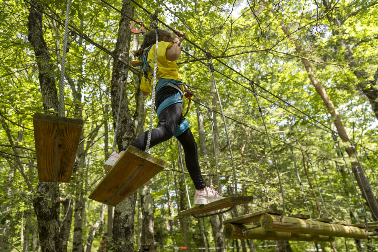 Enfant sur parcours aventure en for�t, pont de singe, camping CLICOCHIC Comps.