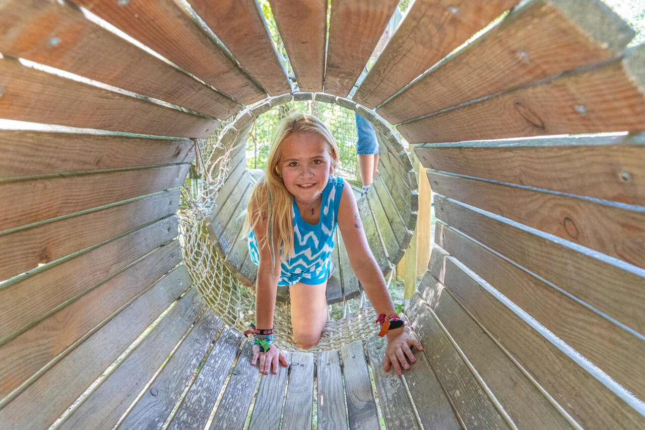 Enfant souriante dans tunnel de jeu au camping CLICOCHIC Source du Jabron � Comps.