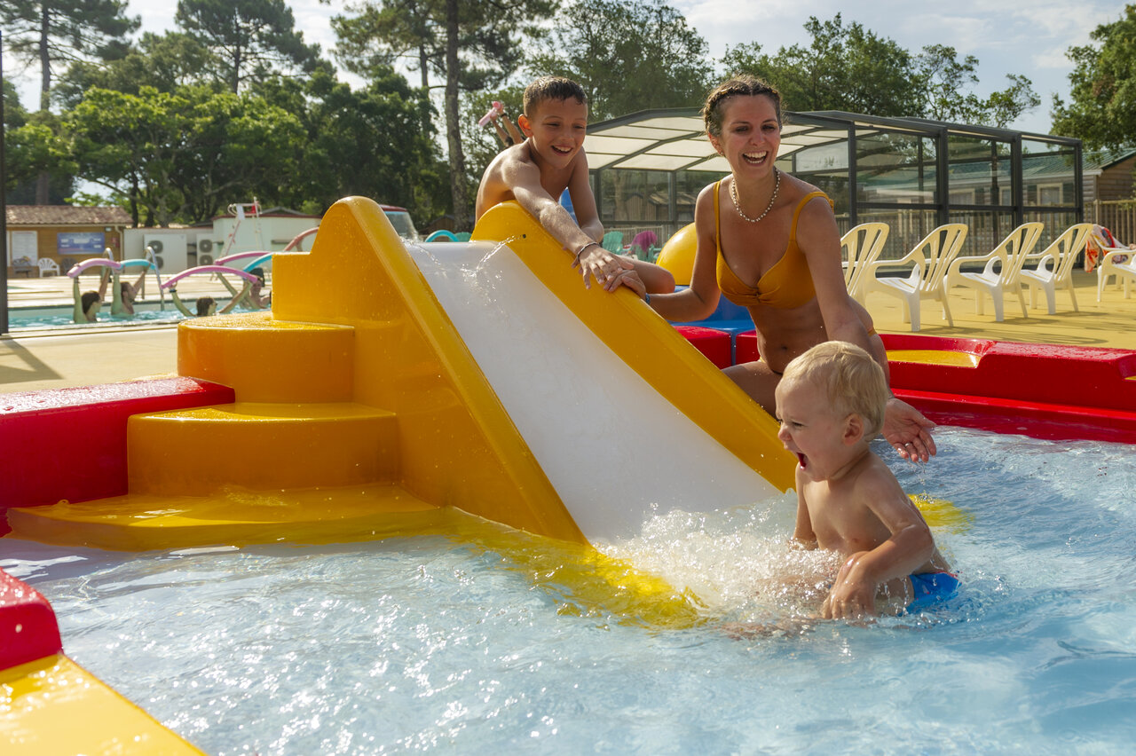 Enfants et famille sur toboggan aquatique en piscine au camping CAPFUN Sud Land.