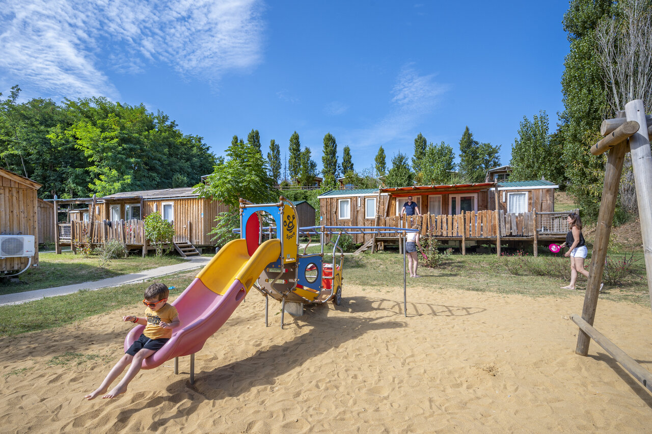 Aire de jeux avec toboggan et Mobile-homes au camping CAPFUN Temps Libre � BOUGE CHAMBALUD (38).