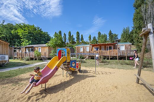 Aire de jeux avec toboggan et Mobil-homes au camping CAPFUN Temps Libre � BOUGE CHAMBALUD.
