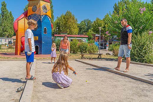 Famille jouant � la p�tanque sur un terrain, avec aire de jeux au camping CAPFUN Temps Libre � BOUGE CHAMBALUD (38).