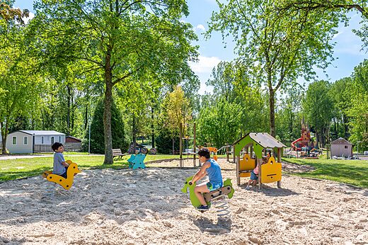 Enfants jouant sur des jeux � ressort dans l'aire de jeux au camping CAPFUN Tensch Jolie � Grostenquin (57).