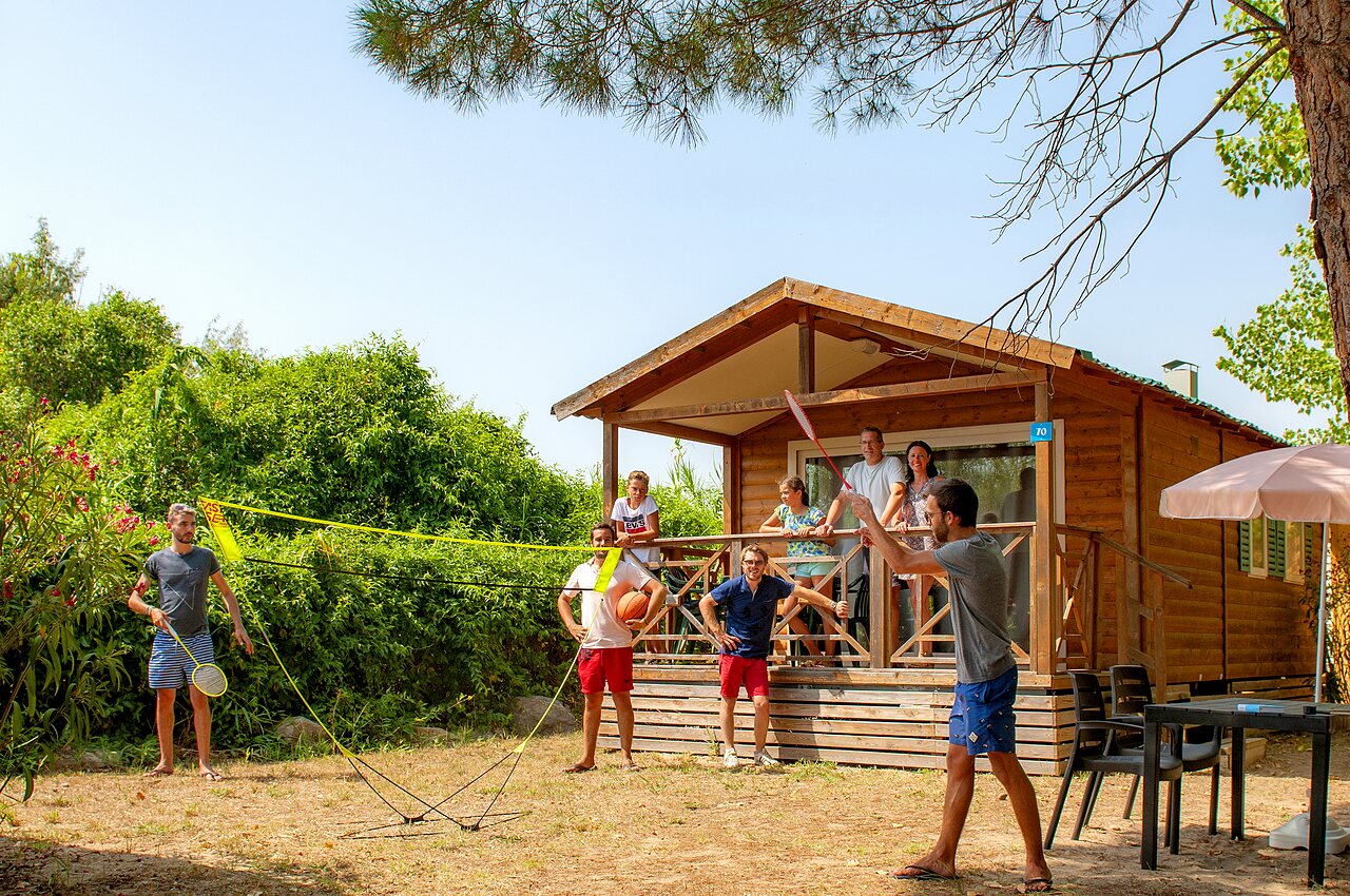 Mobil-home en bois, famille jouant badminton au camping CAPFUN Teorix � MARSEILLAN PLAGE.