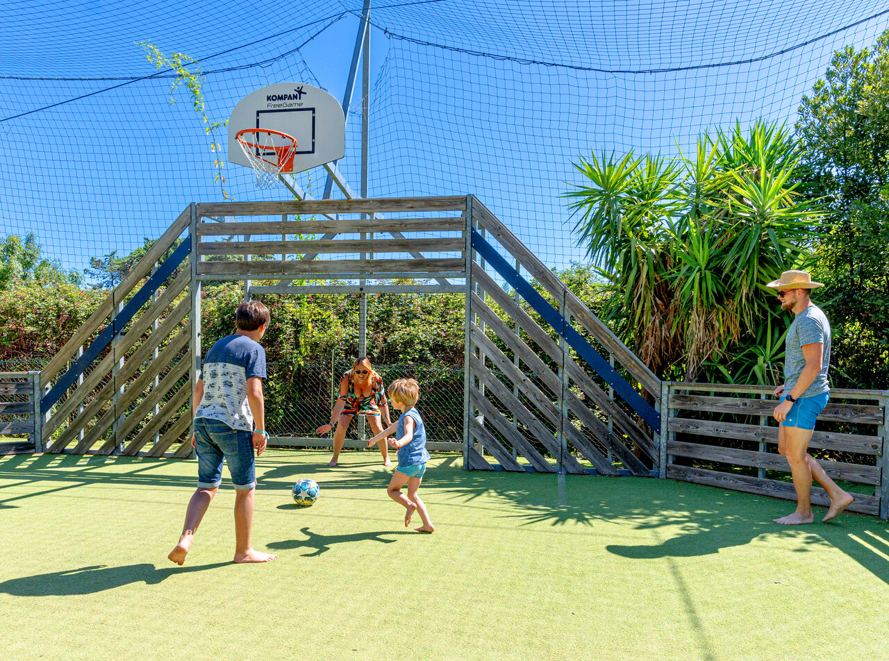 Famille joue au football sur terrain multisport au camping CLICOCHIC Texas, Argel�s.