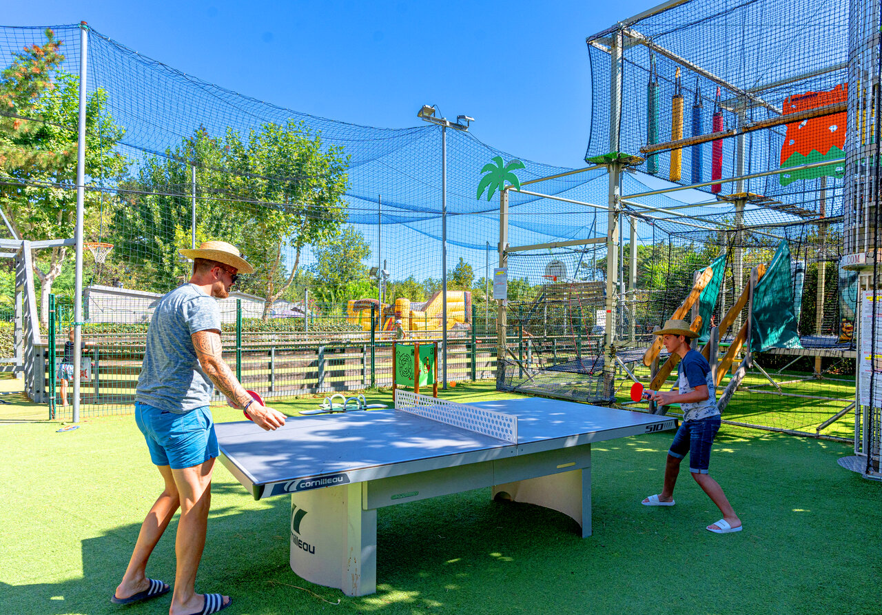 P�re et fils jouent au tennis de table sur gazon au camping CLICOCHIC Texas � Argel�s sur Mer (66).