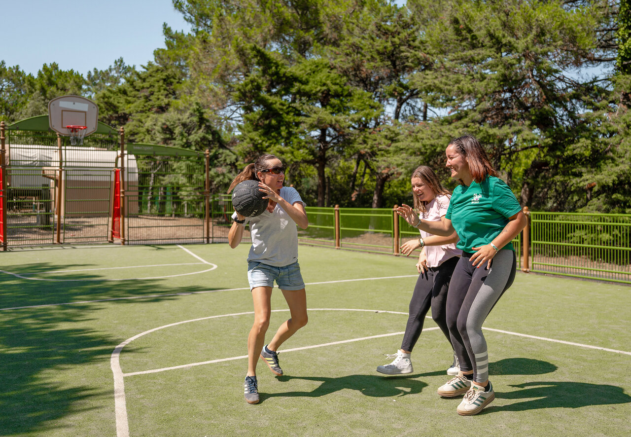 Partie de basketball sur terrain multisport au camping CLICOCHIC Plage des Tonnelles.