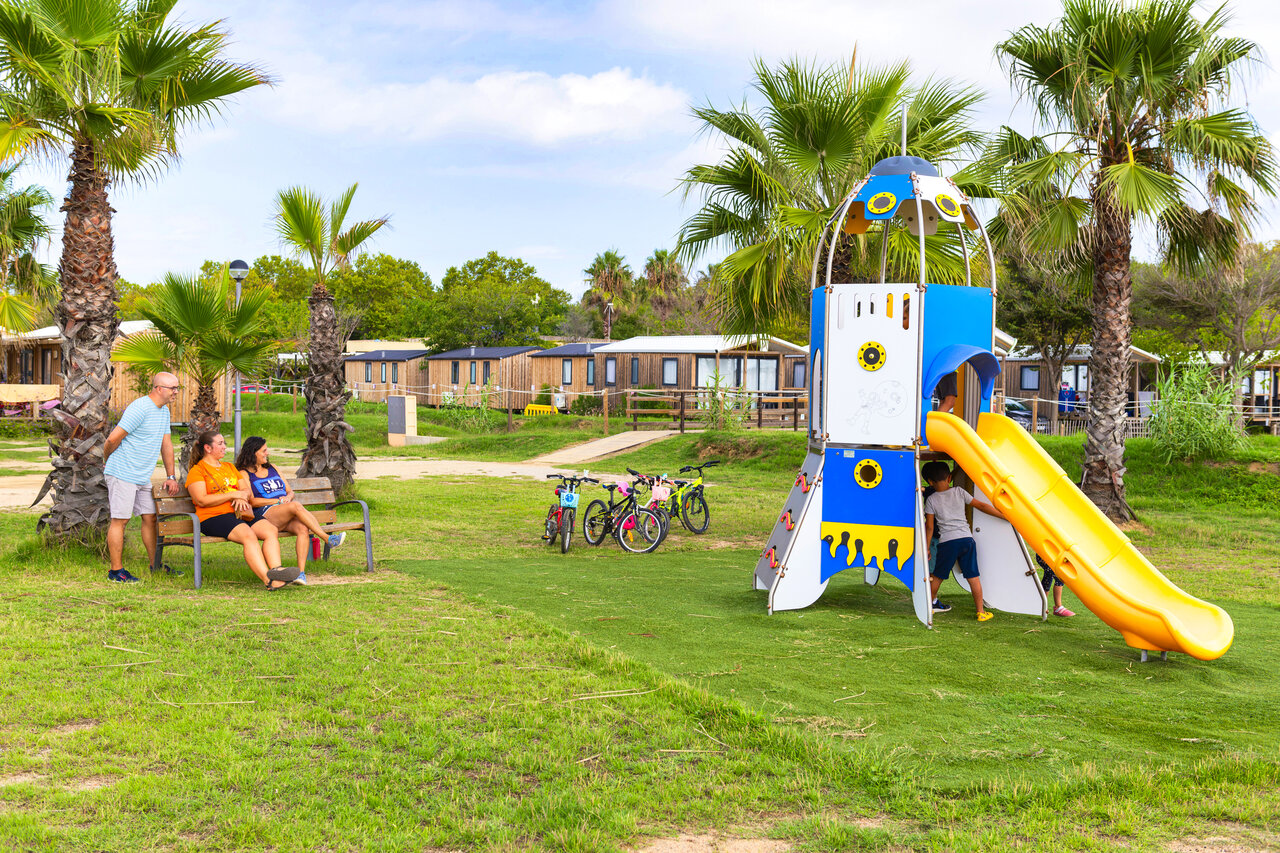 Aire de jeux fus�e avec toboggan, enfants et mobile-homes au camping CAPFUN Tordera-Nacions � Malgrat de Mar.