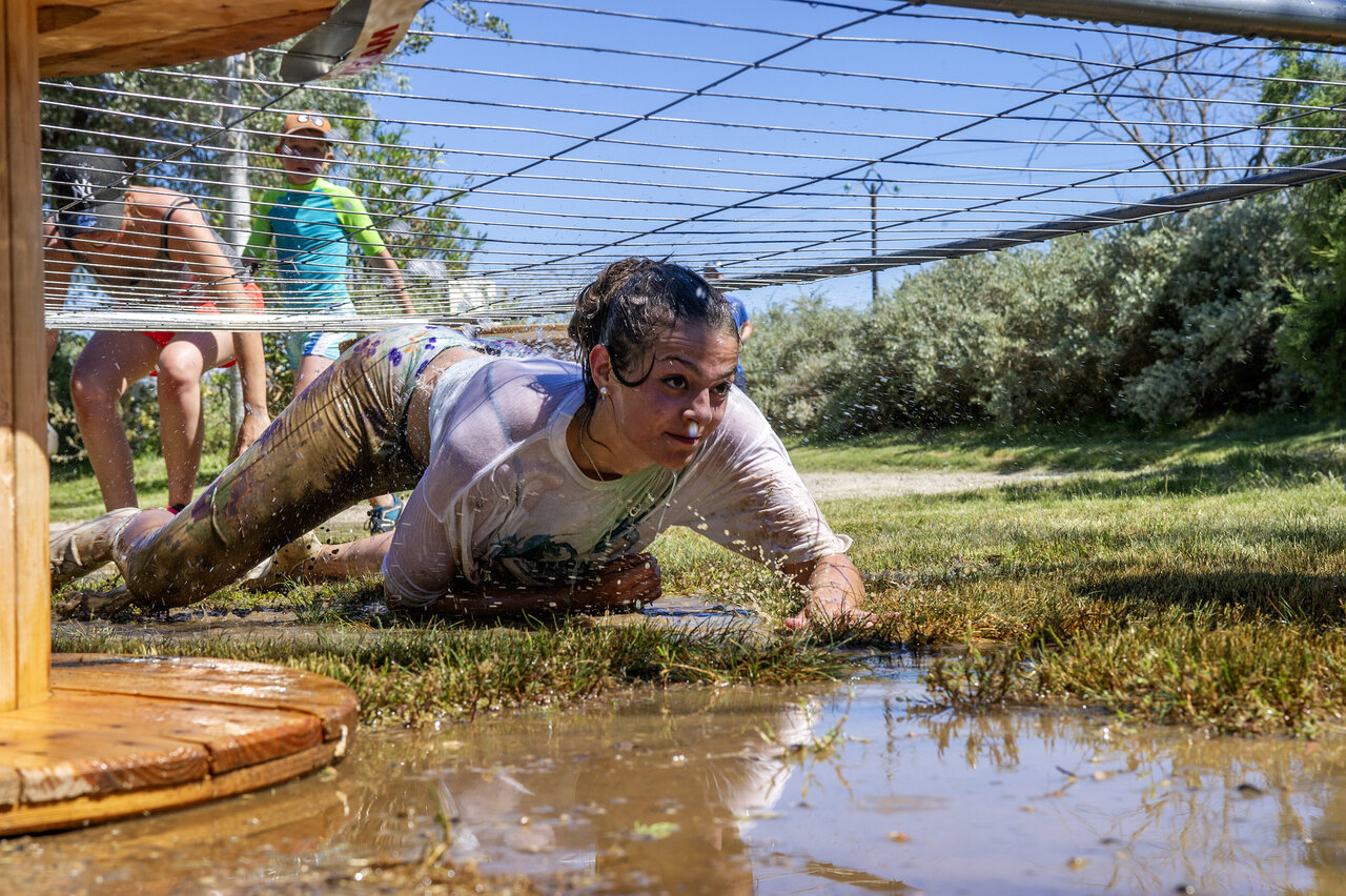 Femme participant � une course d'obstacles boueuse, animation au camping CAPFUN Tordera-Nacions � Malgrat de Mar.