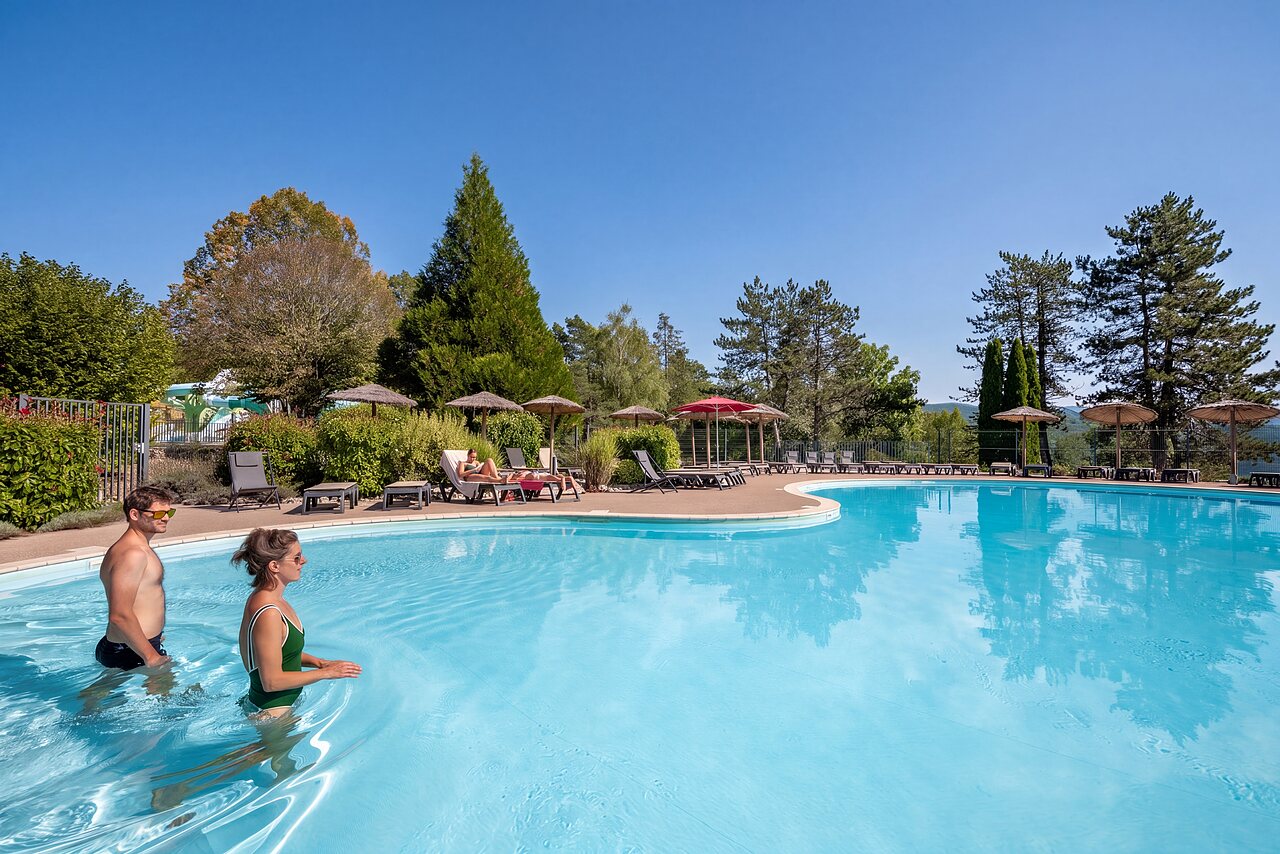 Grande piscine ext�rieure avec baigneurs et chaises longues au camping CLICOCHIC Trelachaume � Maisod (39).