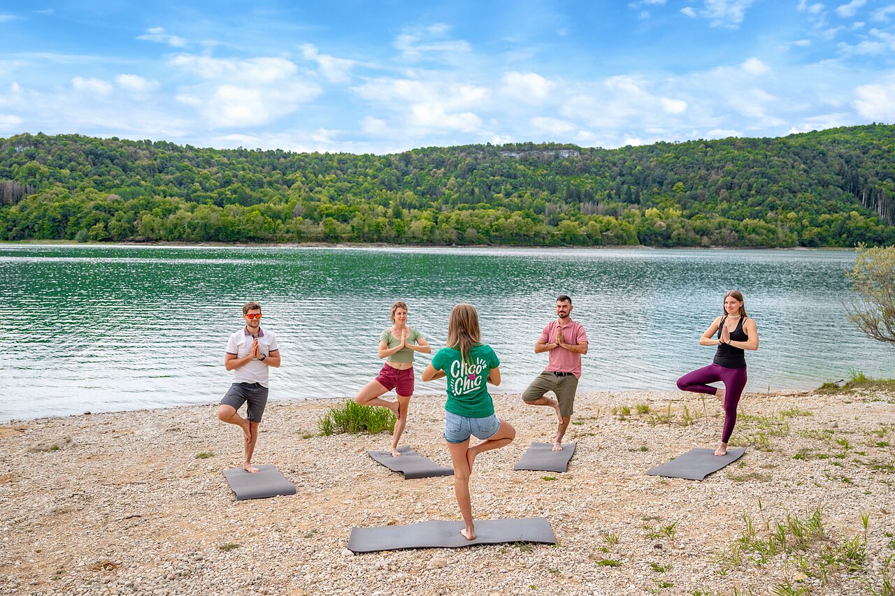 S�ance de yoga en groupe pr�s du lac au camping CLICOCHIC Trelachaume � Maisod (39).