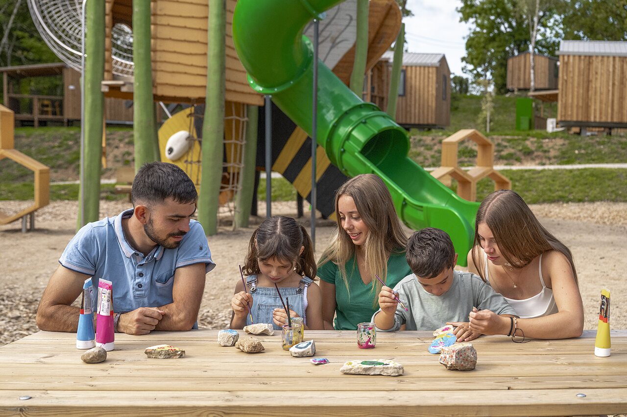 Famille peignant des rochers, aire de jeux au camping CLICOCHIC Trelachaume � Maisod (39).