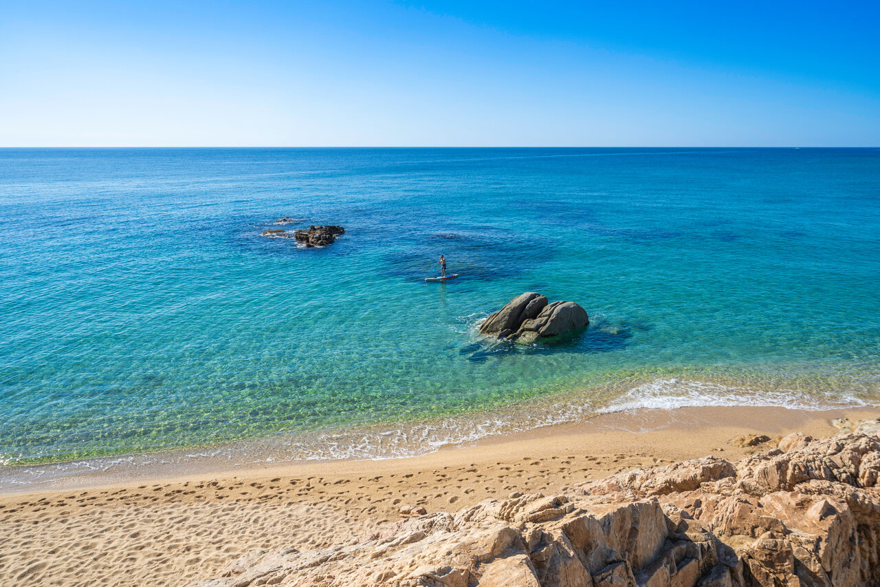 Plage de sable, mer turquoise, paddleboarder au camping CAPFUN Treumal � Platja d'Aro.