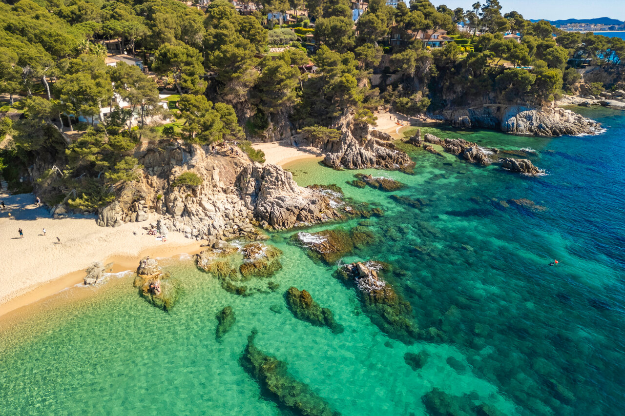 Plage de sable fin, criques rocheuses et mer turquoise au camping CAPFUN Treumal.