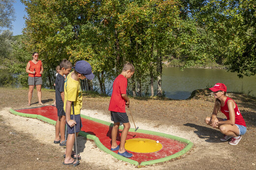 Enfants jouant au mini-golf près du lac au camping CAPFUN Ullule à Tournon d'Agenais (47).