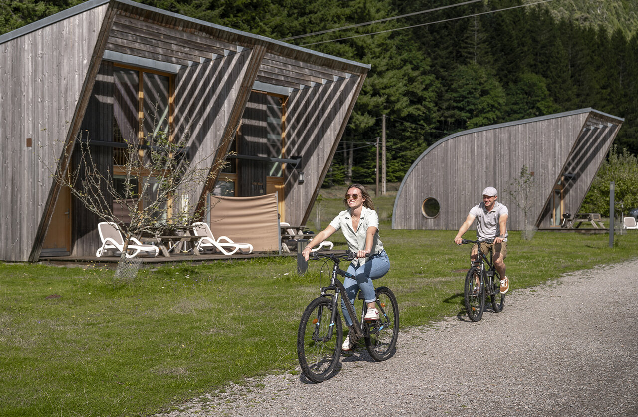 Couple � v�lo devant des Mobil-homes modernes au camping CLICOCHIC Verte Vall�e � XONRUPT LONGEMER (88).