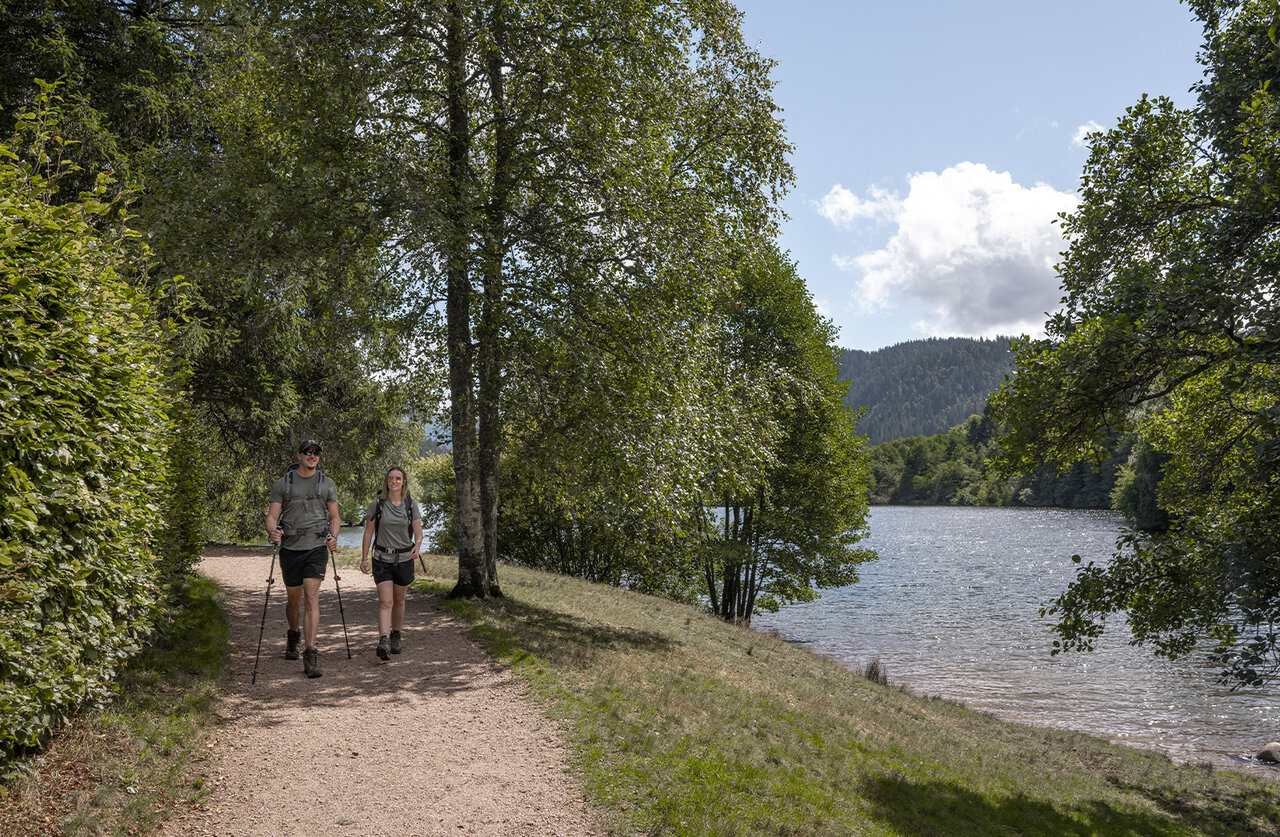 Randonneurs sur sentier au bord du lac, camping CLICOCHIC Verte Vall�e.