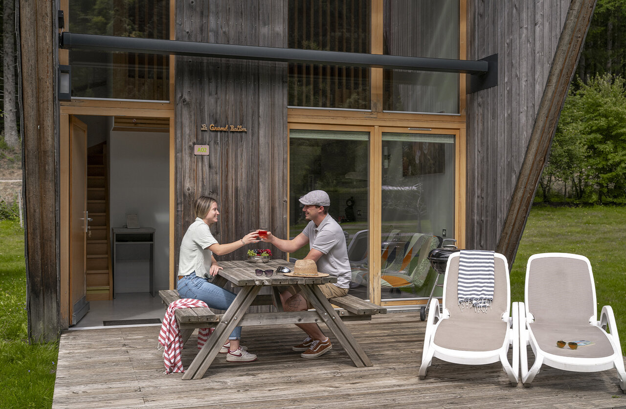 Couple sur terrasse d'h�bergement moderne, camping CLICOCHIC Verte Vall�e, XONRUPT LONGEMER (88).