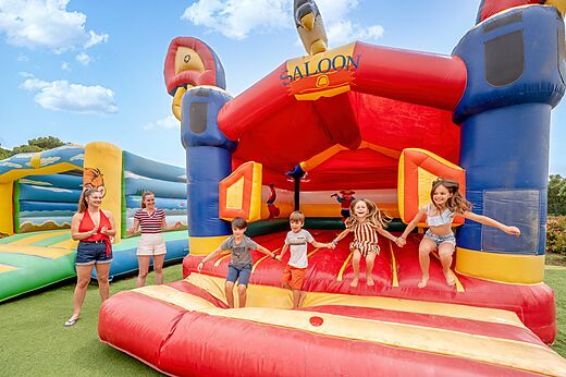 Structure gonflable géante et enfants qui sautent au camping CAPFUN Vignes d'Or à Serignan.