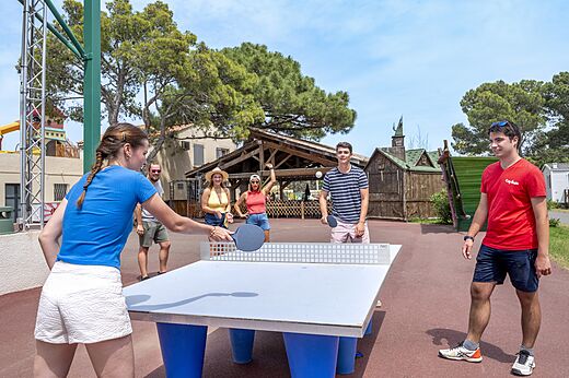 Famille et amis jouant au tennis de table en extérieur au camping CAPFUN Vignes d'Or à Serignan.
