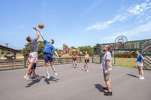 Jeunes jouant au basketball sur le terrain multisport au camping CAPFUN Vignes d'Or.