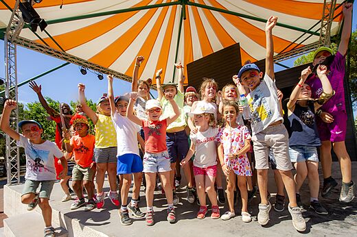 Animation enfants joyeux sur scène avec animateur au camping CAPFUN Vignes d'Or à Serignan.