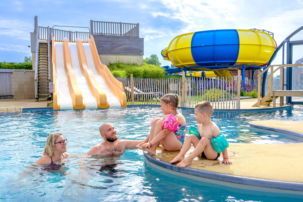 Famille profitant de la piscine et des toboggans au camping CAPFUN Vikings � Saint Jean de la Rivi�re (50).