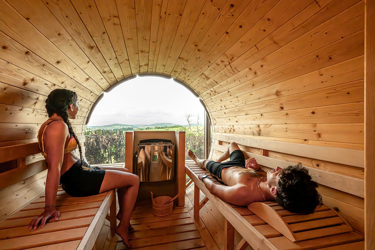 Sauna tonneau, couple relaxant au camping CLICOCHIC Village des Meuniers � Dompierre-les-Ormes.