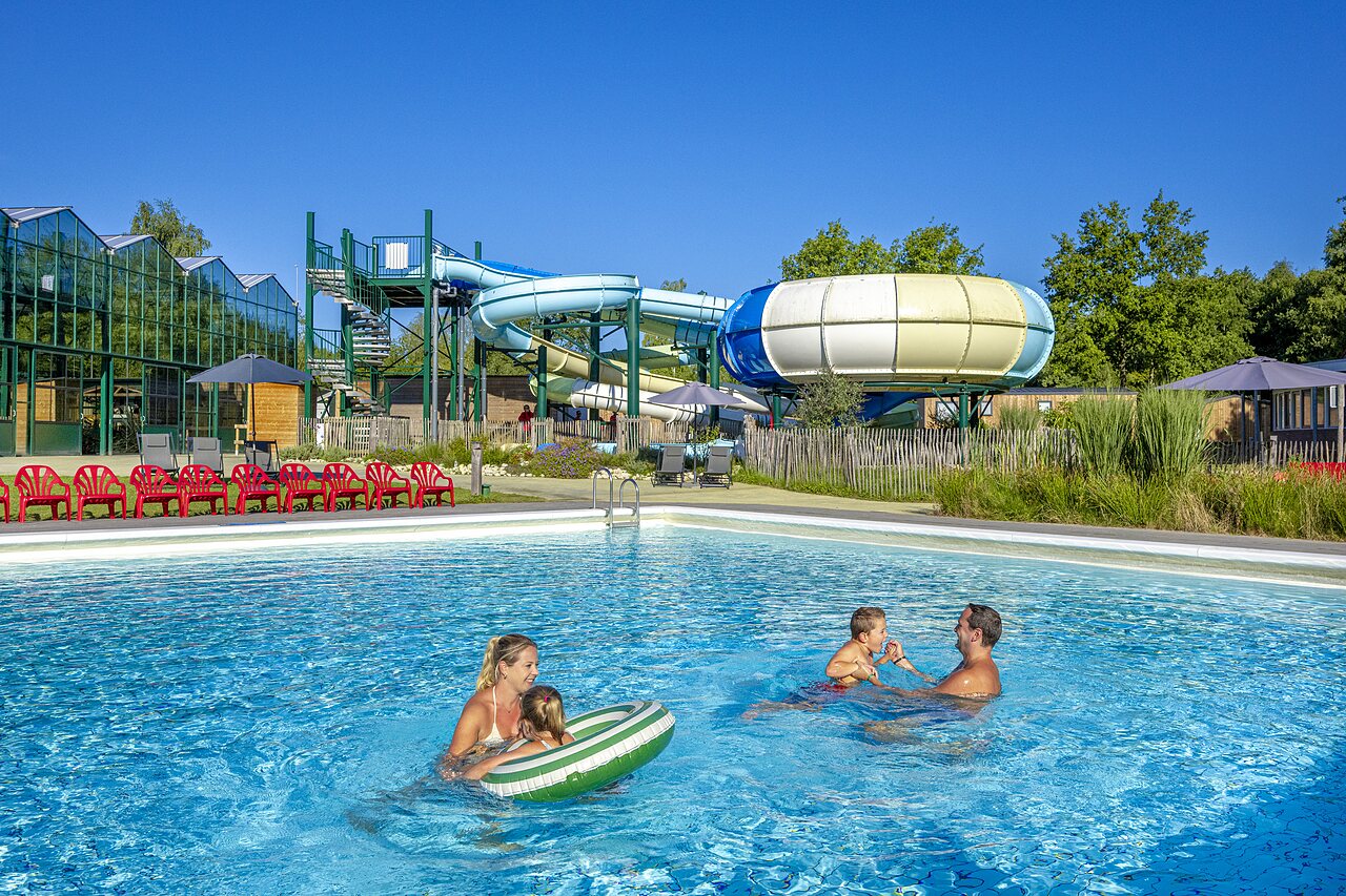 Famille profitant de la piscine ext�rieure avec toboggans au camping CAPFUN Vlinderloo � Enschede.
