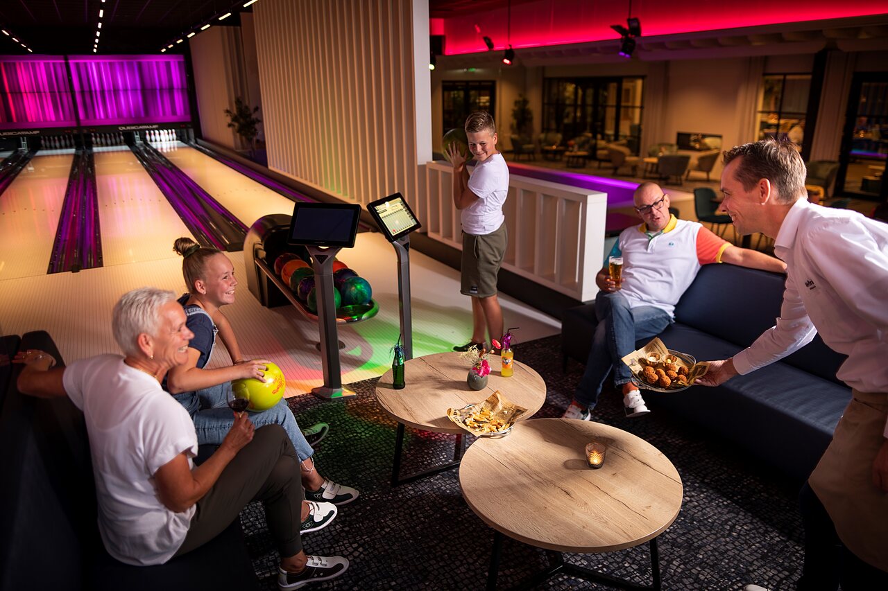 Famille jouant au bowling et service de boissons au camping CAPFUN het Winkel � Winterswijk.