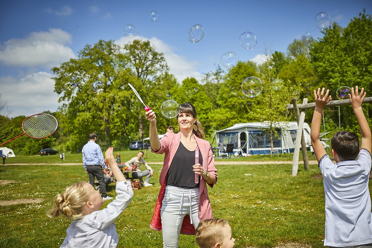 Enfants et parents jouant aux bulles au camping CAPFUN het Winkel � Winterswijk.
