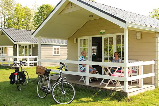 Mobil-home avec couple sur la terrasse, vélos, au camping CAPFUN het Winkel à Winterswijk.