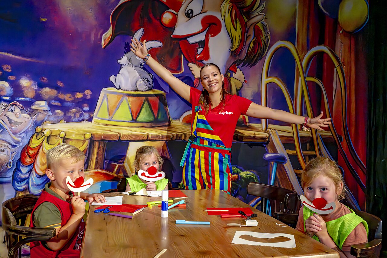 Enfants cr�ant des masques de clown avec l'animatrice au camping CAPFUN de Wondermolen � Molenschot.