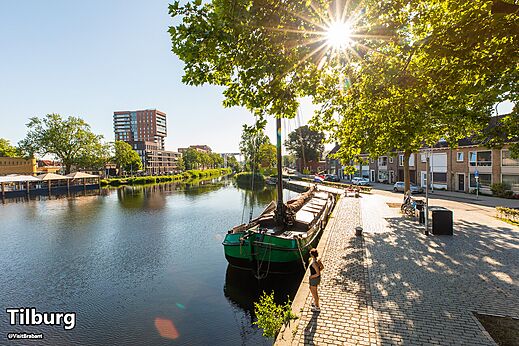 Canal avec bateau traditionnel et architecture moderne à Tilburg, Brabant-Septentrional, à visiter.