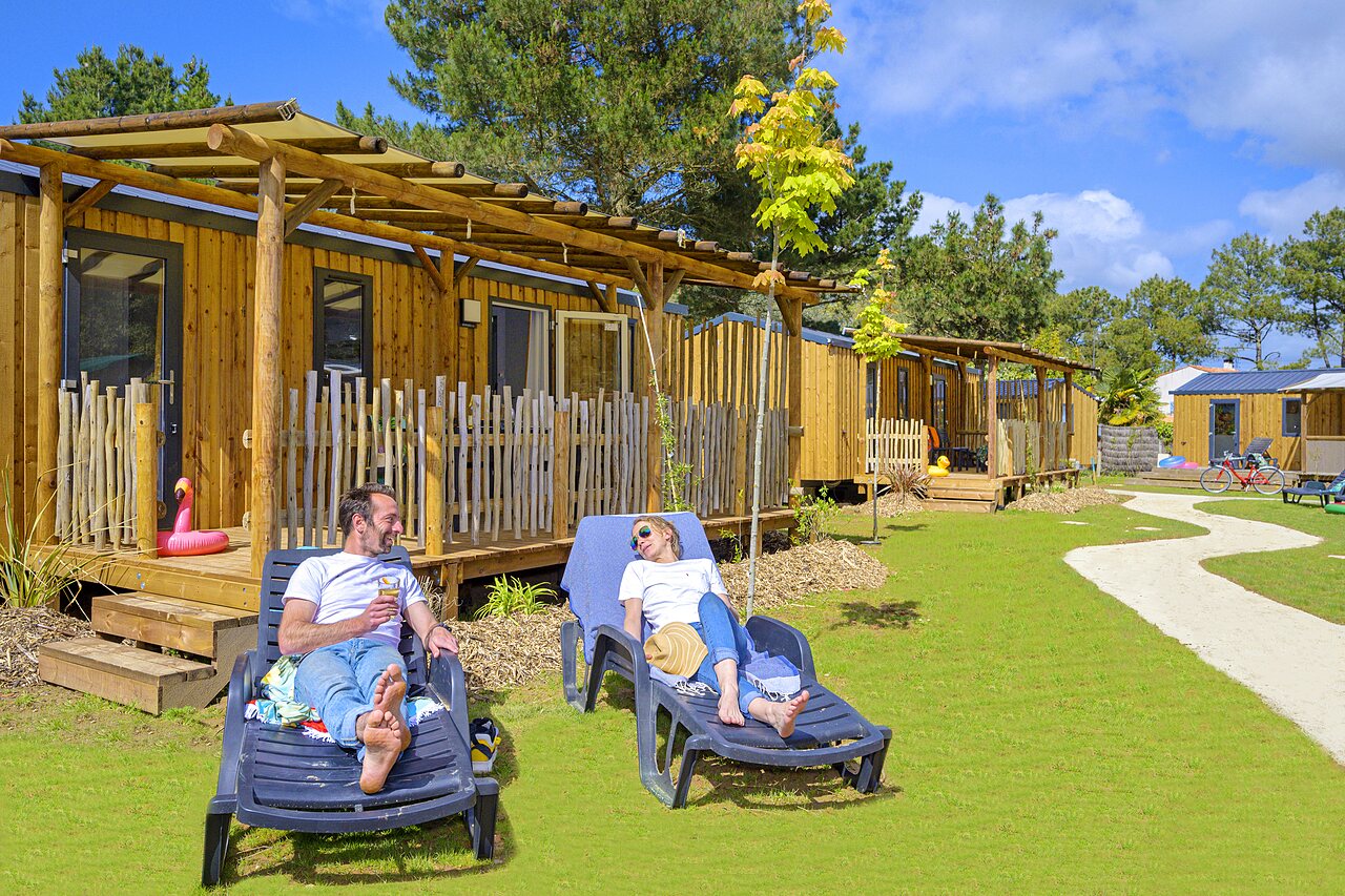Couple relaxant, Mobil-homes en bois au camping CAPFUN Zagarella � LONGEVILLE SUR MER.