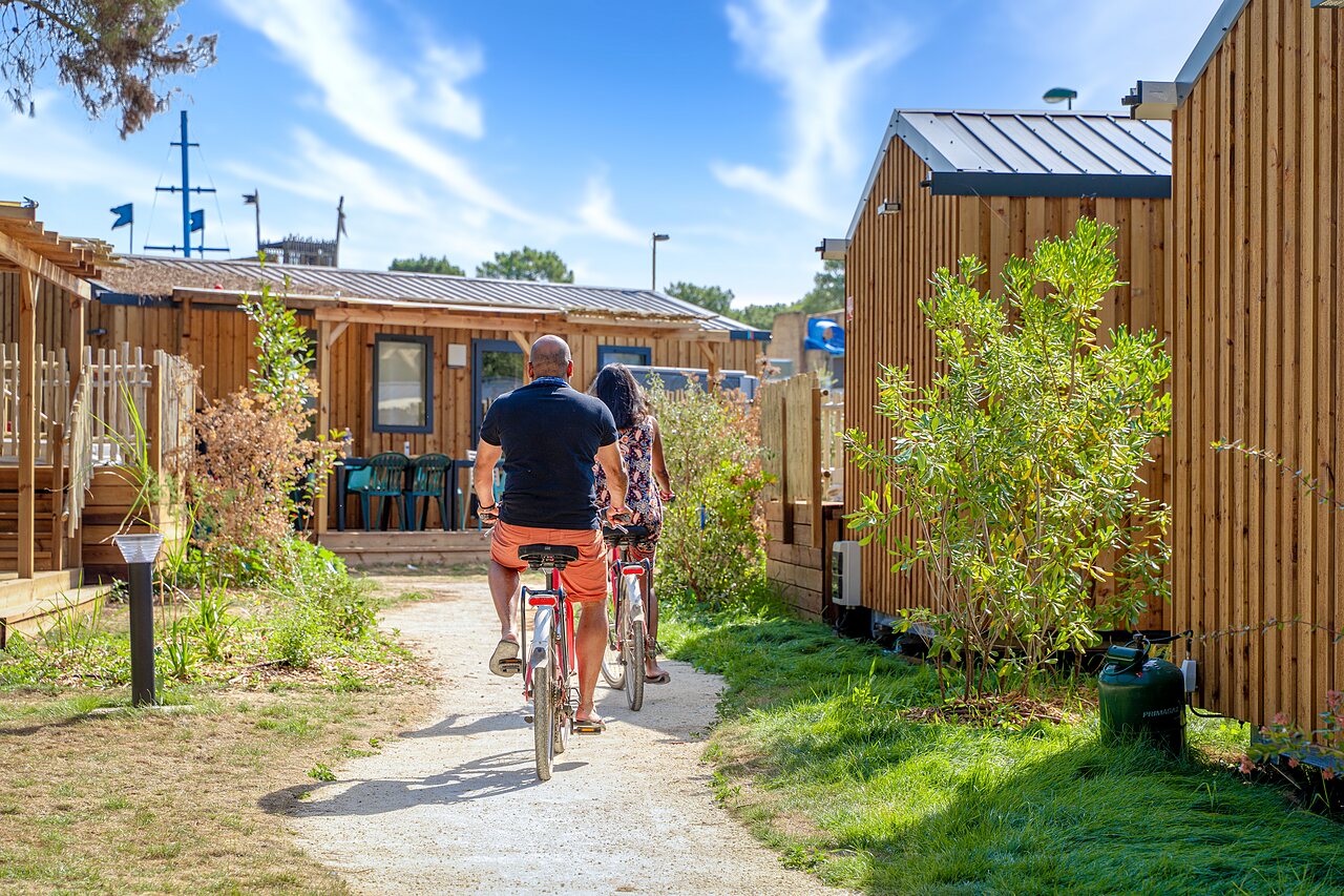 Couple � v�lo sur chemin entre Mobil-homes au camping CAPFUN Zagarella � LONGEVILLE SUR MER (85).
